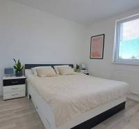A bright bedroom with furnishings and a bed in a 2-room apartment, minimalist design.