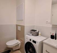 Bathroom in a 2-room apartment with a washing machine, sink, and toilet.