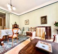 Living room in a two-room apartment with wooden furniture and a colorful carpet.