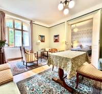 Traditional interior of a 2-room apartment with carpet, furniture, and houseplants.