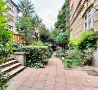 A small garden with greenery next to a residential building on Flöglova Street in Bratislava - Staré Mesto.
