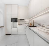 White kitchen with a marble countertop and sink in a 3-room apartment.