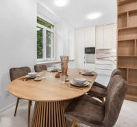 A bright kitchen with an oval table, four chairs, and a large window in a three-room apartment.
