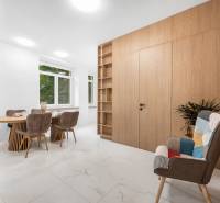 Dining room in a 3-room apartment with a wooden table, chairs, and a decorative armchair.
