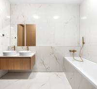 Bathroom with a mirror, double sink, and bathtub in a 3-room apartment.