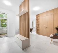 A bright interior of a 3-room apartment with wooden elements and a relaxing chair.