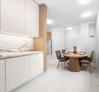 A kitchen with a dining table and four chairs in a 3-room apartment.