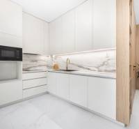 A kitchen in a 3-room apartment with white cabinets and a marble countertop.