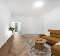 Living room in a 3-room apartment with a brown sofa and wooden furniture.