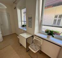 A kitchen with windows, a table with chairs, flowers on the windowsill, a 2-room apartment.