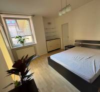 A bright bedroom with a large window and a double bed in a 2-room apartment.