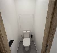 Toilet in a 3-room apartment with white walls and wooden doors.