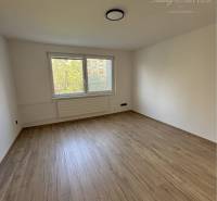 A spacious room with a wooden floor and a window in a 3-room apartment.