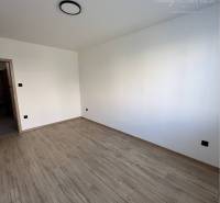 A room with a wooden floor and white walls in a 3-room apartment.
