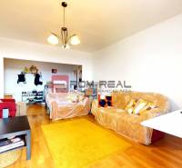 Living room in a 3-room apartment with comfortable sofas and wooden flooring.