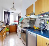 A kitchen in a 3-room apartment with wooden cabinets and appliances.
