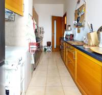 A kitchen in a 3-room apartment with a wooden cabinet and a spice rack.