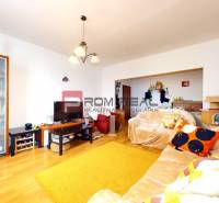 Living room in a 3-room apartment with wooden flooring, shelves, and sofas.