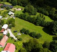 Aerial view of recreational plots in Oščadnica surrounded by greenery and buildings.