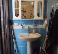 Bathroom in a 3-room apartment with blue tiles, a sink, and a wall cabinet.