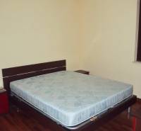 Bedroom in a 3-room apartment with a double bed and wooden flooring.