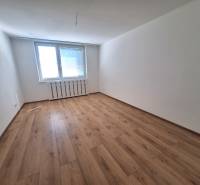 An empty room with a wooden floor and a large window, in a 2-room apartment.