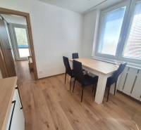Dining area with a wooden table and chairs in a 2-room apartment.
