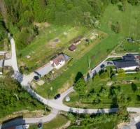 Aerial view of plots - housing in the town of Raková surrounded by greenery and roads.
