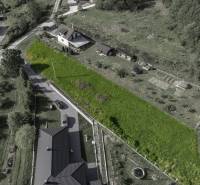 Aerial view of residential plots in Raková, surrounded by greenery and houses.