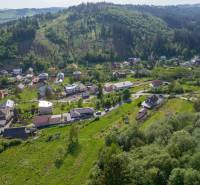 Aerial view of residential plots in Rakov surrounded by greenery and hills.