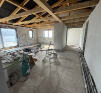 Construction in a family house with exposed beams and building materials on the floor.