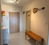 Entrance hallway in a 2-room apartment with a wooden bench and a decorative guitar on the wall.