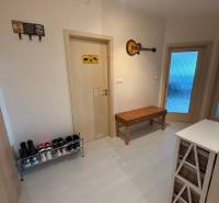 Hallway of a 2-room apartment with a shoe cabinet, bench, and wall decoration.