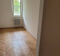 A room in a 3-room apartment with a wooden floor and a radiator under the window.
