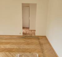 A room with a wooden floor and a white wall in a 3-room apartment.
