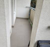 A narrow balcony in a 3-room apartment with a railing and tiles.