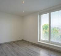 A room with a wooden floor decor and a large window in a 2-room apartment.
