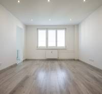 A bright room in a 2-room apartment with a window and a floor with a wooden decor.