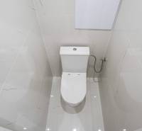 Bathroom in a 2-room apartment with white tiles and a toilet.