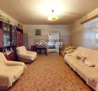 Room in a cottage with a blue carpet, wardrobe, chandelier, wooden floor.