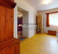 A room in a cottage with a wooden bed and a dressing table, a bright room with a large window.