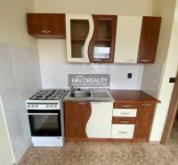 A small kitchen with a gas stove and a kitchenette in a studio apartment; rustic design.
