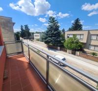 A balcony on a family house in Nové Zámky with a view of a quiet street and greenery.