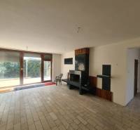 Fireplace in a family house with large windows and tiles, seating area.