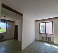 The interior of a family house with a tiled floor and a wooden beam on the ceiling.