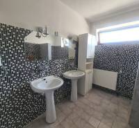 A bathroom with two sinks and mosaic tiles in a family house.