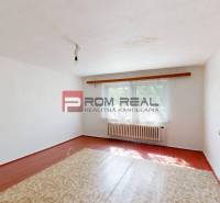 A room with white walls and a wooden floor in a family house.