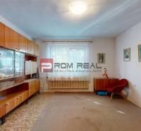 Living room of a family house with furniture, a large window, and curtains.