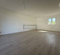 A spacious room in a family house with wooden flooring and white walls.