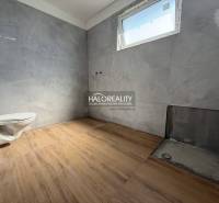 A bathroom in a family house with tiles and a free-standing toilet, waiting to be finished.